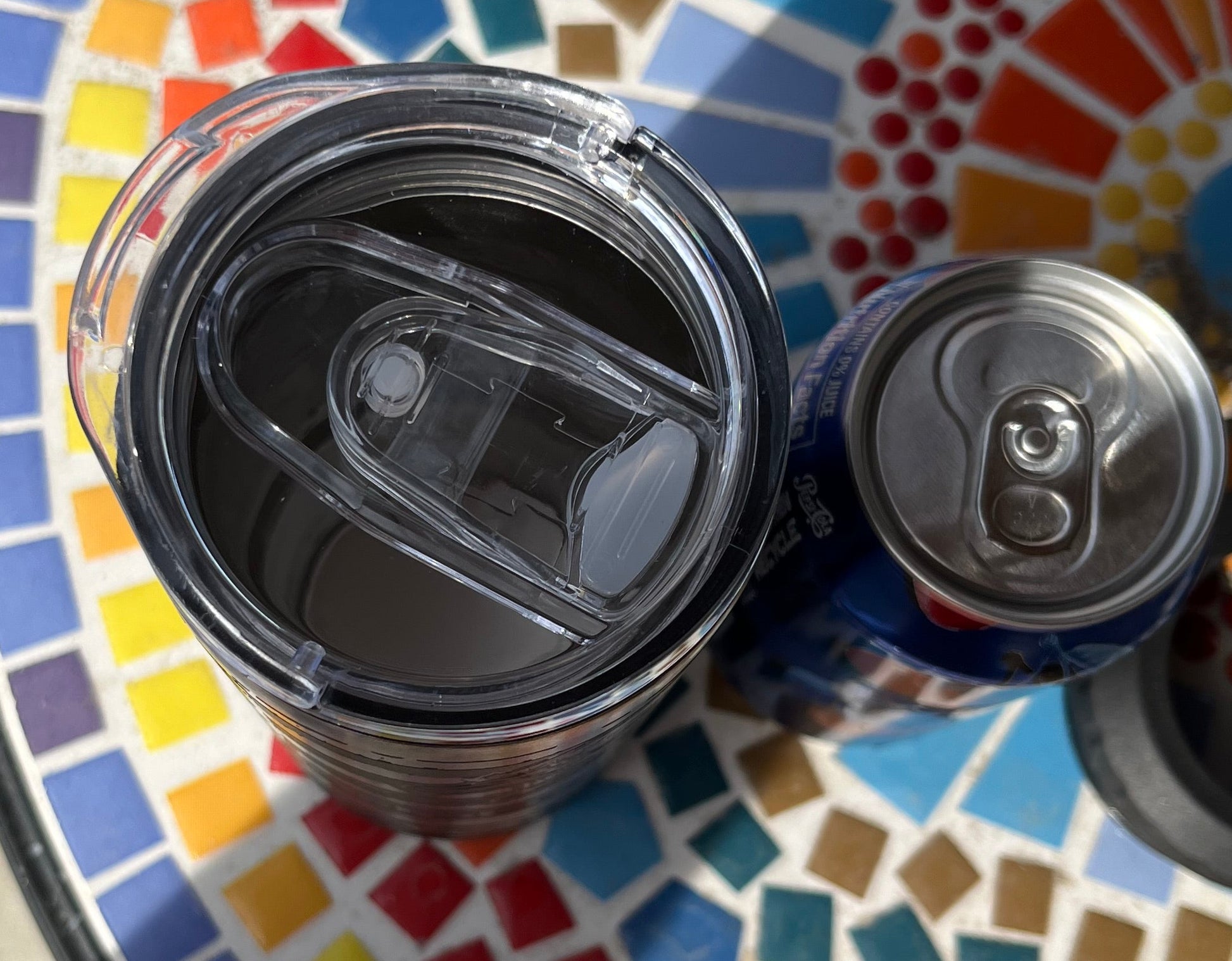 Two cans on a colorful mosaic table