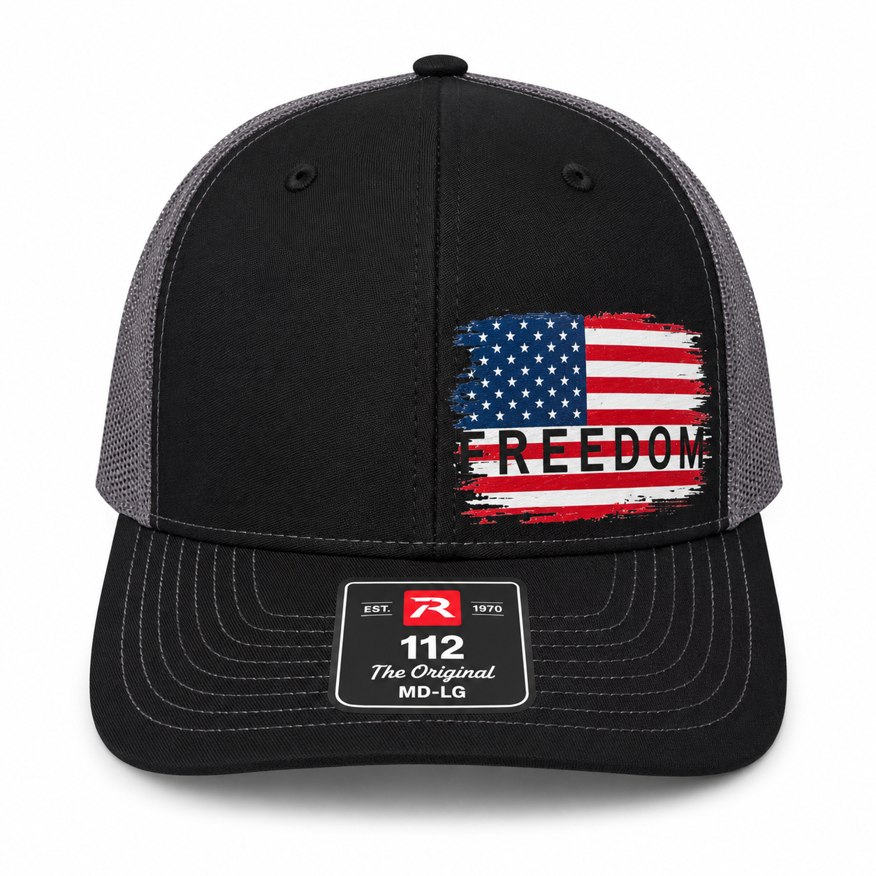 A black and gray trucker-style cap with a distressed American flag graphic on the front panel and the word 'FREEDOM' printed across it. The brim has a visible size and brand patch reading '112 The Original MD-LG'.