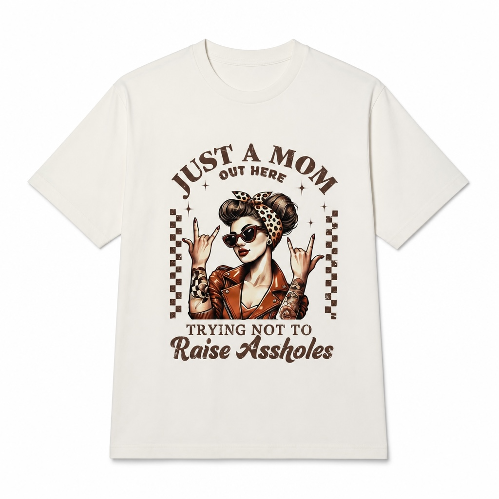 Funny “Just a Mom Out Here Trying Not to Raise Assholes” retro rockabilly graphic t-shirt featuring a tattooed mom wearing sunglasses, a leopard print headband, and a leather jacket.