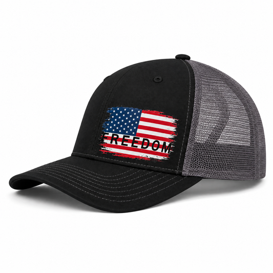 A black and gray trucker-style cap with a distressed American flag graphic on the front panel and the word 'FREEDOM' printed across it, shown on a clean white background.